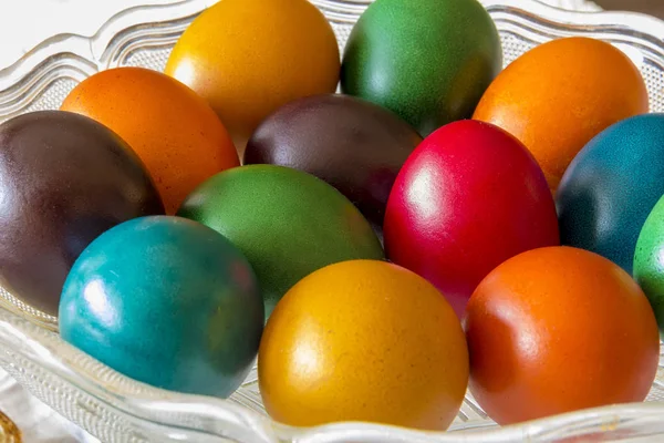 Many Easter colored eggs in the basket.  Colorful, red, green ,blue, yellow and orange eggs