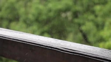 Yağmur damlasına yakın bir yerde, ahşap korkuluklara çarpıyor..