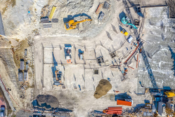 Construction equipment working at the construction site. Aerial view from drone