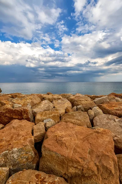 Kleurrijke Stenen Een Oever Met Pluizige Wolken Aan Horizon Verticaal — Stockfoto