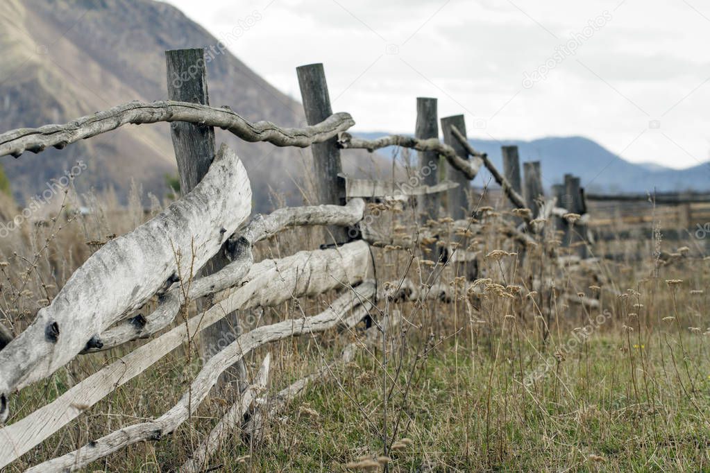 Old wooden fencing on mountain backgruond. Rustic landscape.