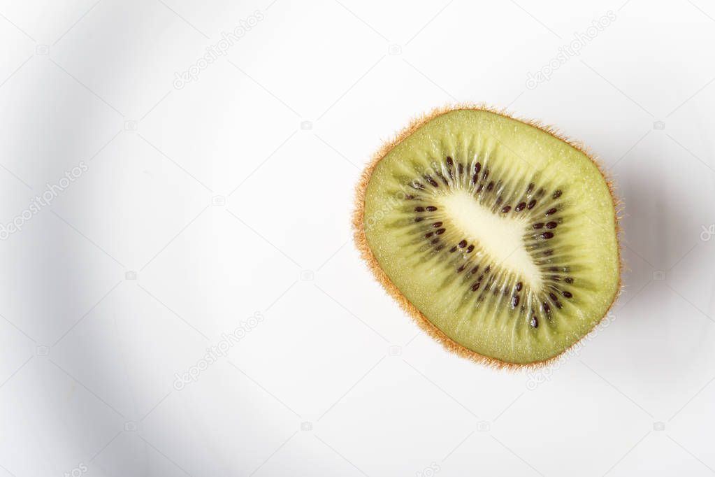 Fresh organic kiwi fruits on white plate for healthy breakfast or dinner. Copy space. Dietary vegetarian food. Top view.