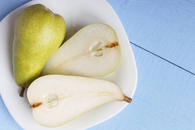 Armut closeup beyaz tabakta. Yukarıdan ahşap masa üzerinde görüntüleyin. Uzay kopyalayın. Sağlıklı vejetaryen gıda kavramı.