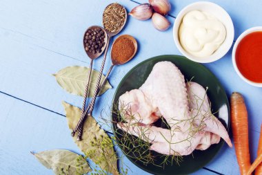 Sağlıklı yemek için taze malzemelerle rustik ahşap masa. Diyet beslenme için doğal baharat ile çiğ tavuk kanatları. Üstten görünüm. Kopya alanı.