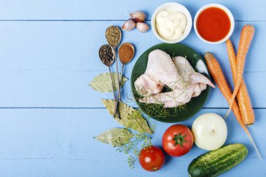 Tavuk kanadı ve ahşap bir masa üzerinde taze organik sebze. Diyet beslenme için malzemeler. Üstten görünüm. Kopya alanı.