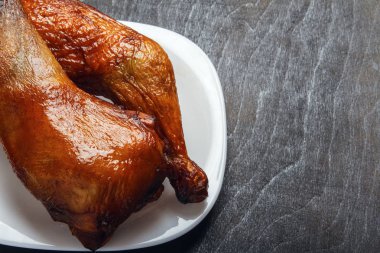 Tavuk budu portre siyah bir arka plan üzerinde beyaz bir plaka üzerinde bir ızgarada pişirilir. Üstten görünüm yukarıdan. Uzay kopyalayın. Doğal gıda.