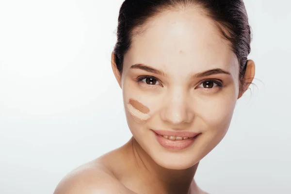 Prachtig gezicht van jonge vrouw met cosmetische foundation op een huid. Schoonheidsbehandeling — Stockfoto