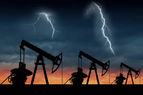 日落时三台油泵的剪影 在日落的油田 暴风雨的天空与闪电 — 图库照片