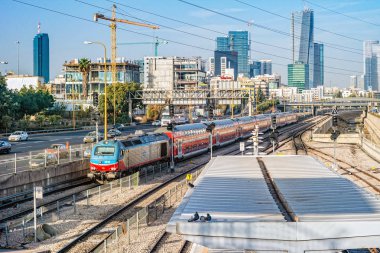 Tel Aviv, İsrail - Kasım, 2016: Görünümüne tren istasyonu ve Tel Aviv'de yeni gökdelenler üzerinde kırmızı tren.