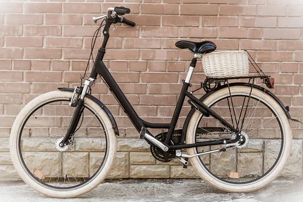 Black retro vintage bicycle with old brick wall.