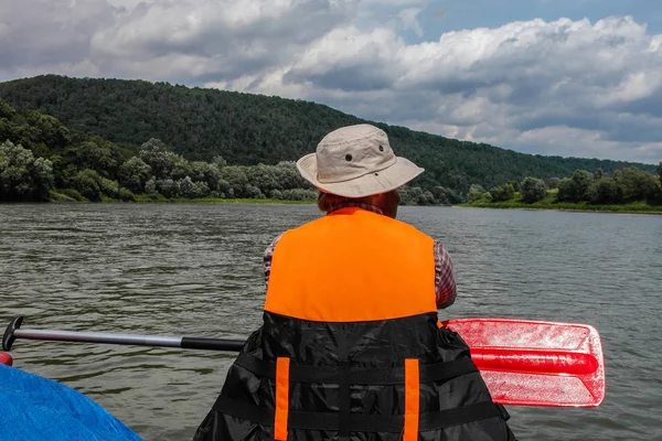 L'uomo in giubbotti di salvataggio arancioni galleggiava sul fiume . — Foto Stock