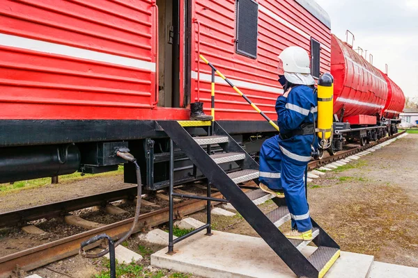 Hasák na ochranné uniformě stojící vedle požárního vlaku. — Stock fotografie