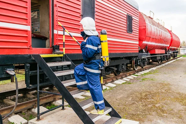 Hasák na ochranné uniformě stojící vedle požárního vlaku. — Stock fotografie