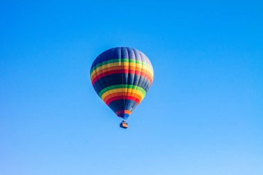 Mavi gökyüzünde renkli sıcak hava balonları.