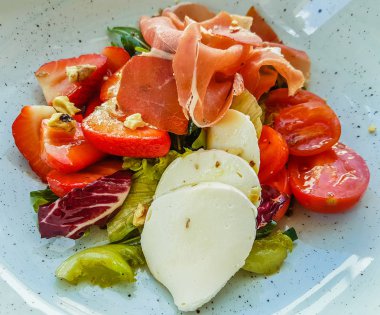 Orijinal hamon, kiraz domates, çilek ve mozzarella salatası.
