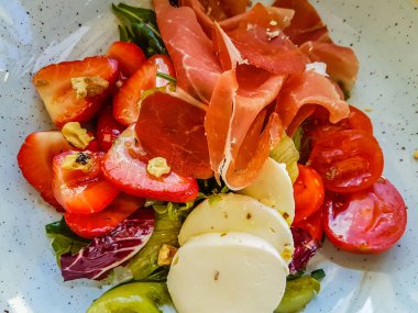 Orijinal hamon, kiraz domates, çilek ve mozzarella salatası.