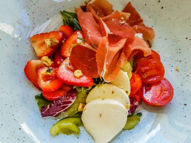 Orijinal hamon, kiraz domates, çilek ve mozzarella salatası.