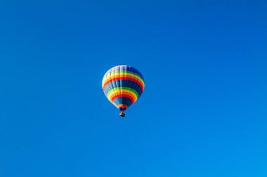 Mavi gökyüzünde renkli sıcak hava balonları.