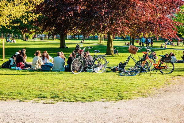 Люди отдыхают в королевском саду рядом с замком Русенборг
