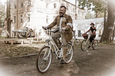 Frankivsk 'in Retro Cruise' u. Retro kostüm giyen ve bisiklet tüvit işine katılan insanlar Retro Cruise 'u yönetiyor..