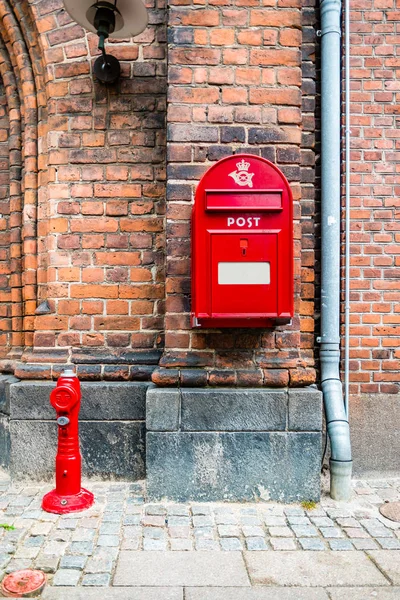 デンマークのHelsingorにあるレンガの壁に対する赤い消火栓と赤い郵便箱 — ストック写真