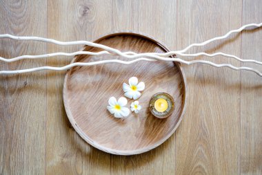 Feng shui yuvarlak ahşap tepsi, mum, dal ve dekor zen meditasyonu, mindfulness veya masaj, görünümü natürmort yukarıda pampering için beyaz güzel çiçekler