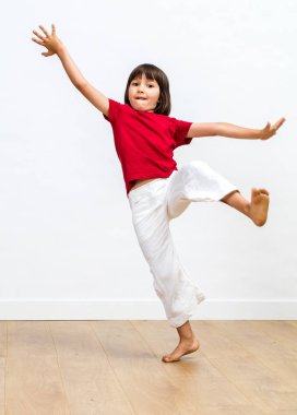 dengesizlik ile oynayan dövüş sanatları uygulamak veya spor salonu, bayılma heyecanlı genç çocuk çıplak ayakları ve silah ahşap zemin, beyaz arka plan üzerinde büyüdü