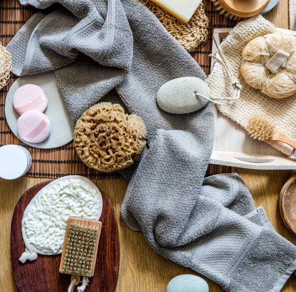 still life with many healthy body care and skincare objects - natural sponge, loofah, body and manicure brushes for traditional green beauty, top view