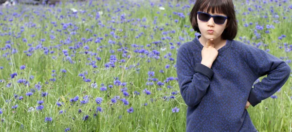 Inspired child with sunglasses determined over a natural impressionist garden — Stock Photo, Image