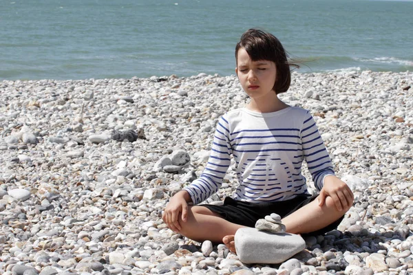 Calmo bambino meditando per la pace interiore, il benessere e la saggezza, spiaggia — Foto Stock