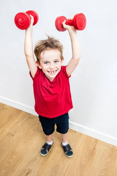 Niño feliz disfrutando levantando pesas ganando para expresar el éxito — Foto de Stock