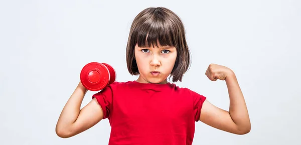 Cheeky child pouting, raising hands with dumbbell and strong fist — Stock Photo, Image