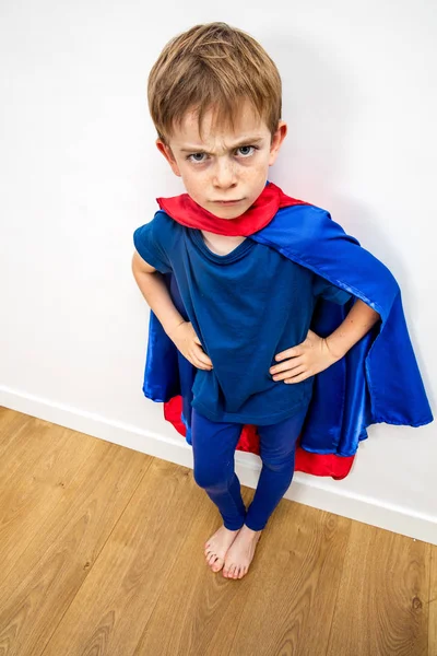 Zły superbohater dziecko jest irytowany przez oczerniające edukacji, białe tło — Zdjęcie stockowe