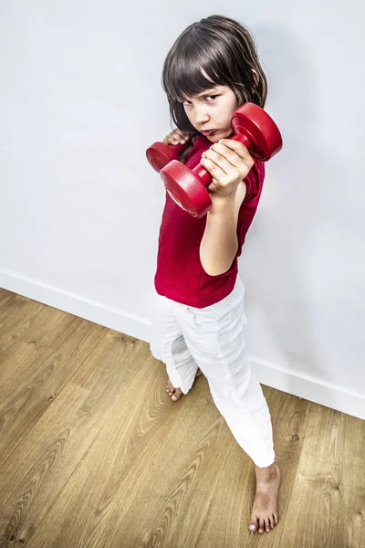 Rebellious child raising dumbbells for girl-boy body language — Stock Photo, Image