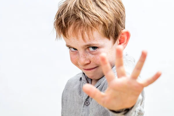 Sınırlarını göstermek için elini ileri uzatan kararlı bir çocuk.