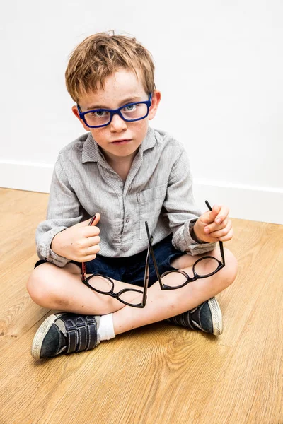 Niño confundido con muchas gafas en las manos recogiendo el cuidado de los ojos — Foto de Stock