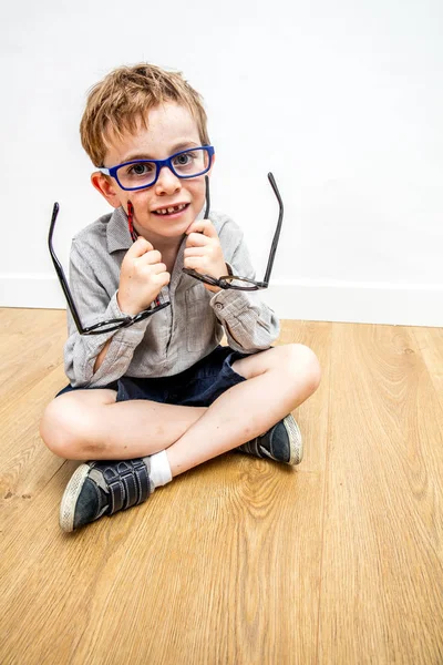 Sorrindo menino tendo dilema, gostando de pegar novos óculos — Fotografia de Stock