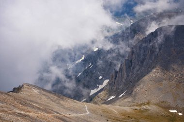 Kayalık bir patika boyunca yürüyen turistler. Yüksek dağ yamaçlarının manzarası. Dağ yürüyüşü. Olimpos Dağı 'nda gezinti. Yunanistan. Ulusal Park.
