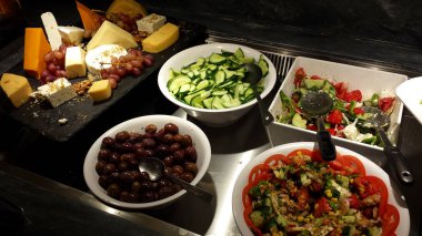 Yunan salata, zeytin, dilimlenmiş salatalık ve çeşitli peynirler.