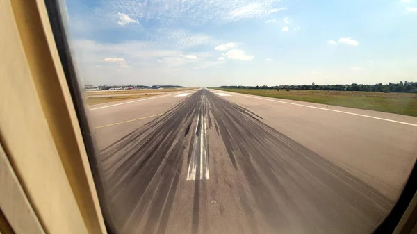 Tire tracks on the runway from the aircraft window