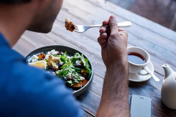 남자의 혼합된 샐러드 접시를 마시는 비스트로 테이블에 — 스톡 사진