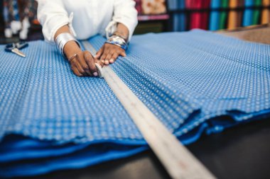 Bir sayaç işaretleme, ayakta ve bir parça kesme önce güzel elbise ölçme bir kumaş dükkanı sahibi closeup