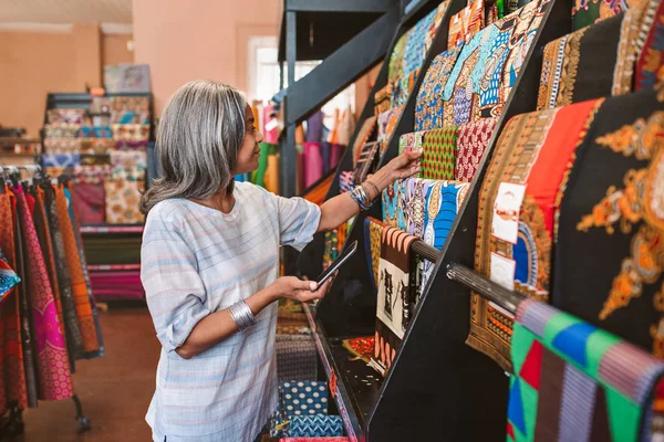 Smiling Mature Shop Owner Using Digital Tablet While Looking Racks — Stock Photo, Image