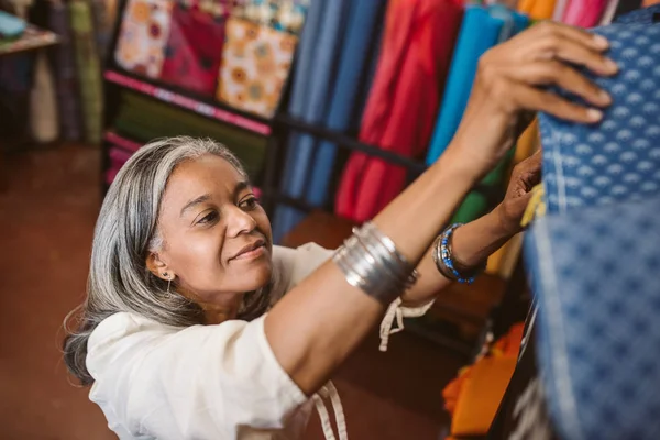 Smiling Mature Woman Standing Fabric Shop Looking Rolls Colorful Textiles — Stock Photo, Image