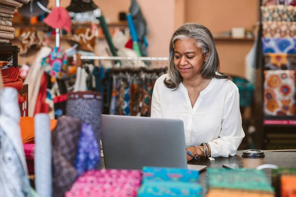 Leende Mogen Tyg Shop Ägare Står Bakom Räknare Omgiven Färgglada — Stockfoto