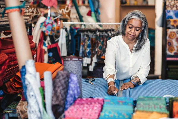 Reife Textilfachverkäuferin Steht Einem Tisch Ihrem Geschäft Und Misst Und — Stockfoto