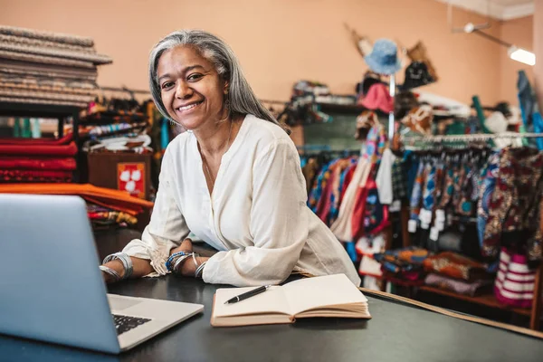 Retrato Sorridente Dono Loja Tecido Maduro Trabalhando Laptop Escrevendo Notas — Fotografia de Stock