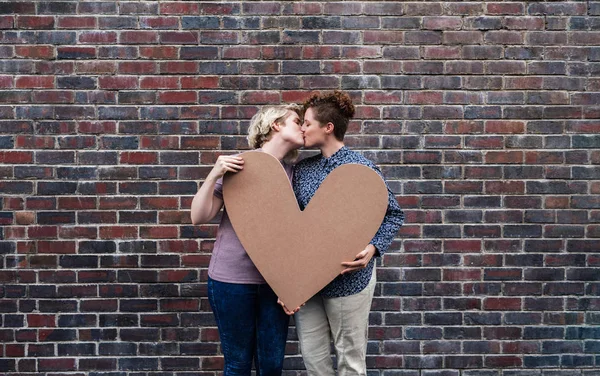 Sevgi Dolu Genç Lezbiyen Çift Ayakta Dışında Bir Kalp Simgesi — Stok fotoğraf
