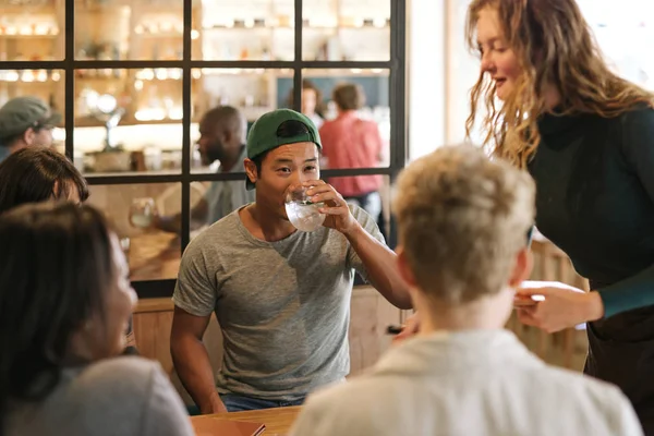 Grupo Diversos Jóvenes Amigos Sentados Una Mesa Bistró Moda Pidiendo —  Fotos de Stock