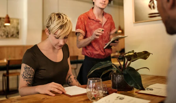 Young Woman Reading Menu While Sitting Group Friends Table Trendy — Stock Photo, Image